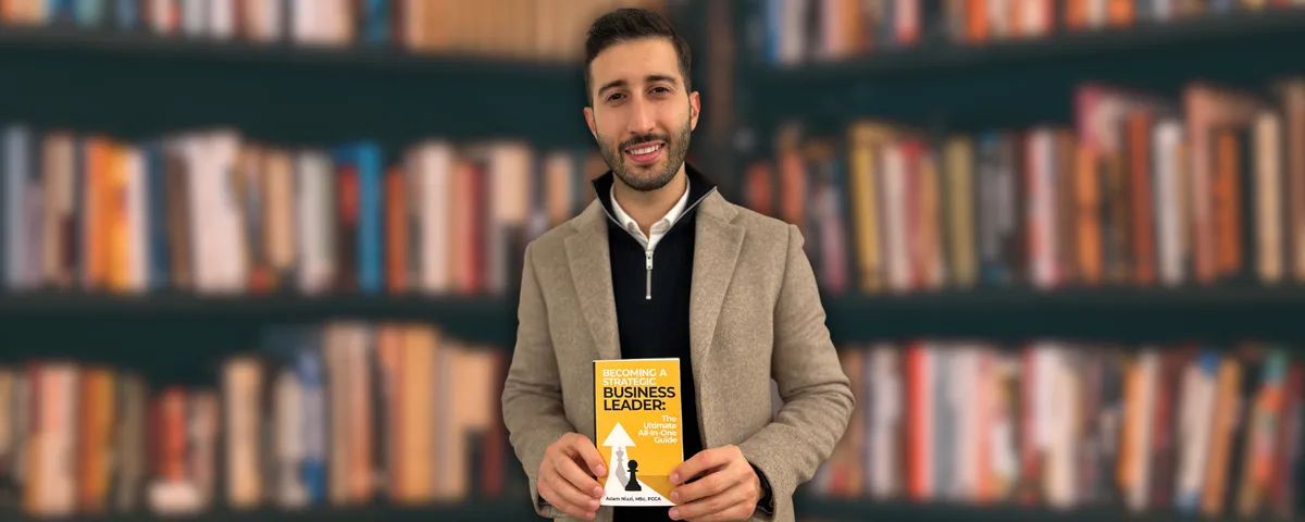 Adam Niazi holding a copy of Becoming A Strategic Business Leader